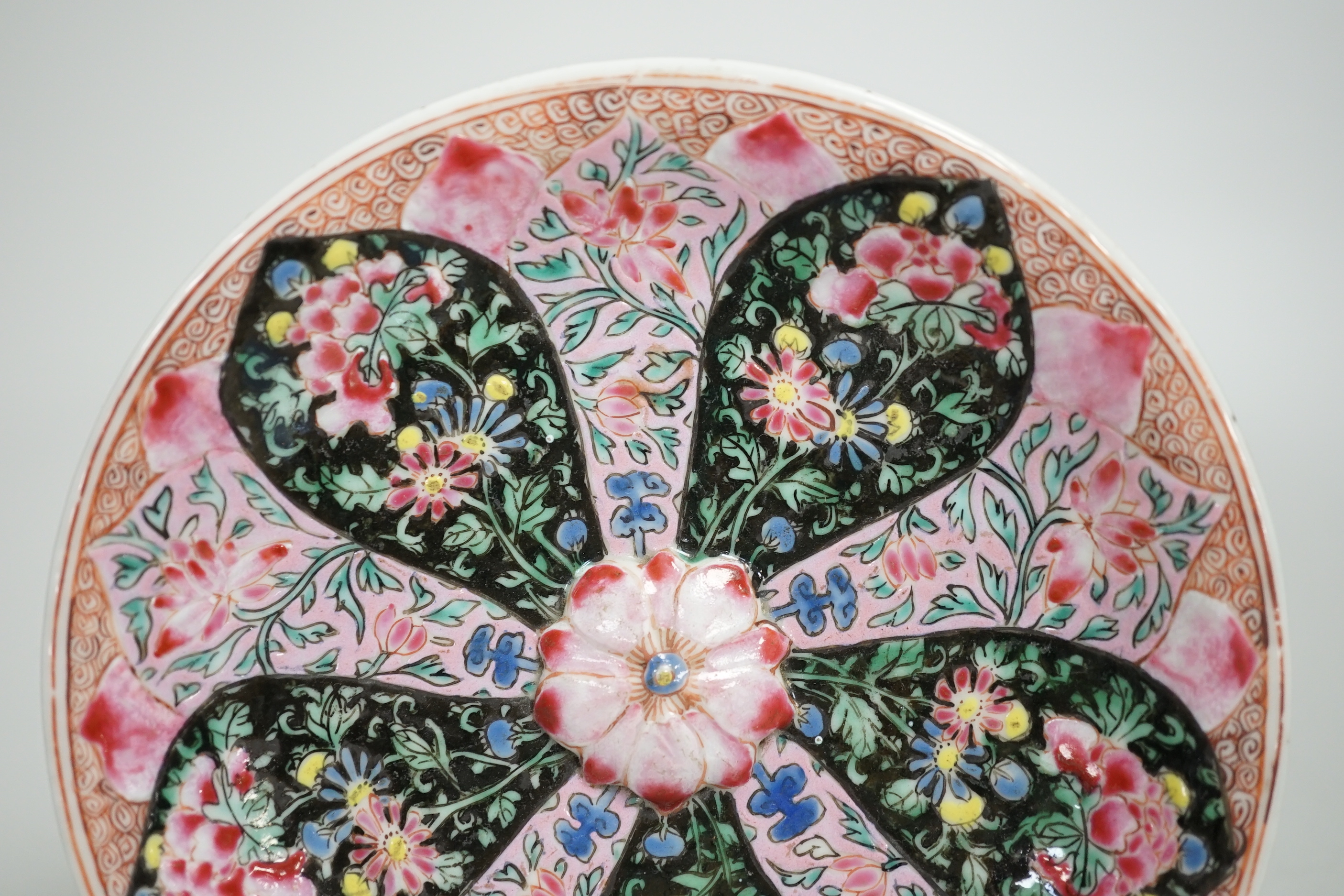 A Chinese famille rose cup stand, early Qianlong period, decorated in relief with a flowerhead, 15cm in diameter